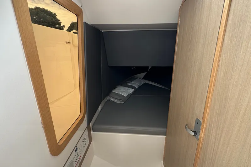Slide: The Image of Interior cabin of 2027 Edgewater 310SC boat with wooden door and window. - 38