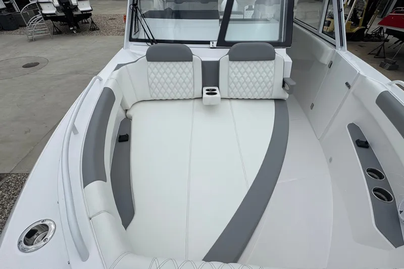 Slide: The Image of 2027 Edgewater 310SC boat interior with white and gray seating, cup holders, and modern design. - 53