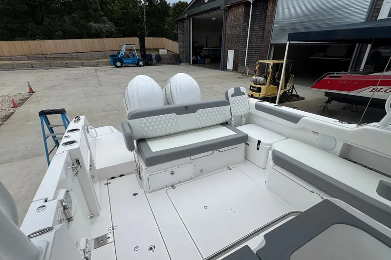 Slide: The Image of 2027 Edgewater 310SC boat interior with seating and dual engines in a marina setting. - 14