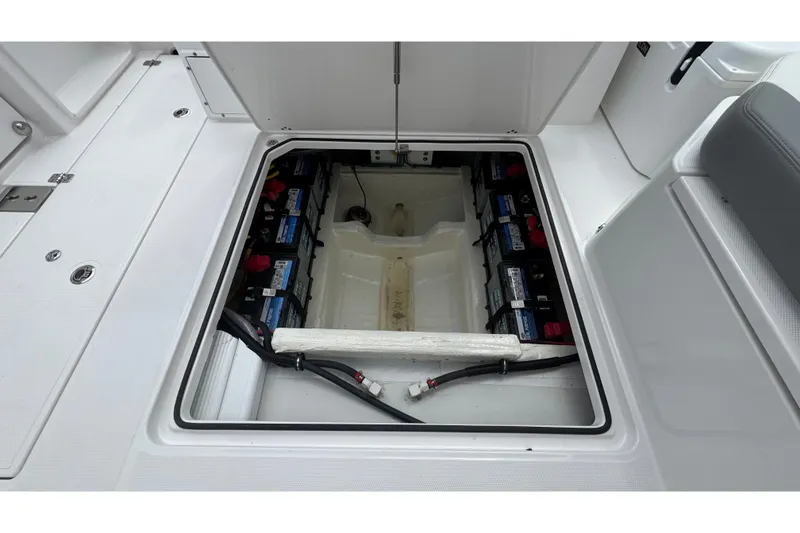 Slide: The Image of View of an open battery compartment with multiple batteries and cables on a boat. - 24
