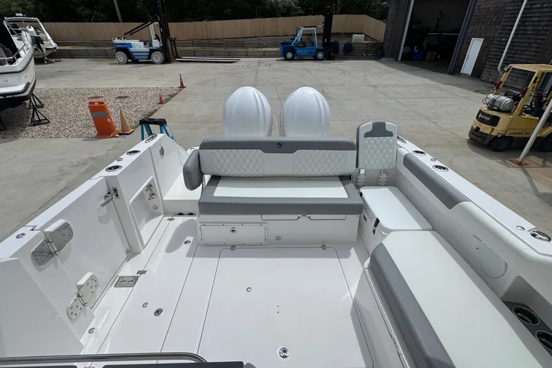 Slide: The Image of 2027 Edgewater 310SC boat interior with seating and storage, docked in a marina. - 23