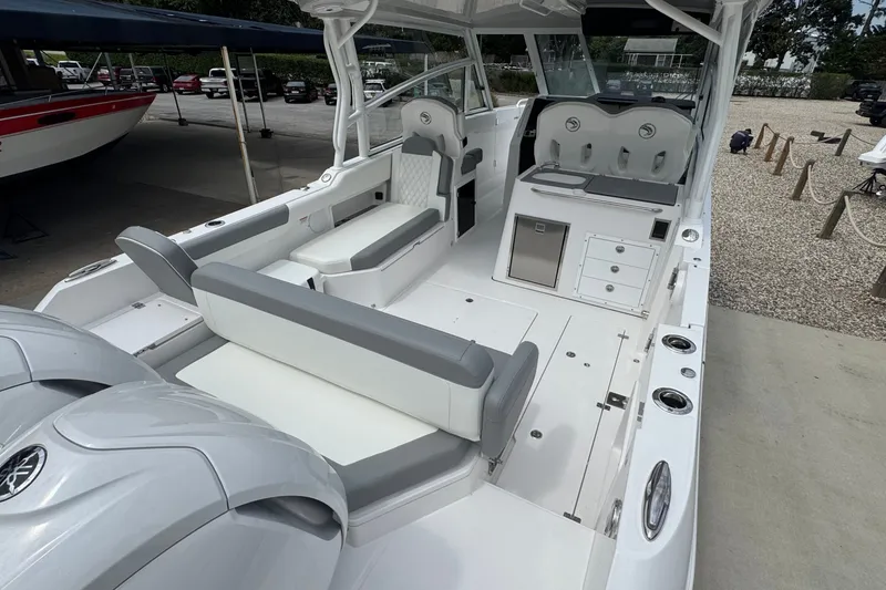 Slide: The Image of 2027 Edgewater 310SC boat interior with seating, storage, and dual engines. - 13