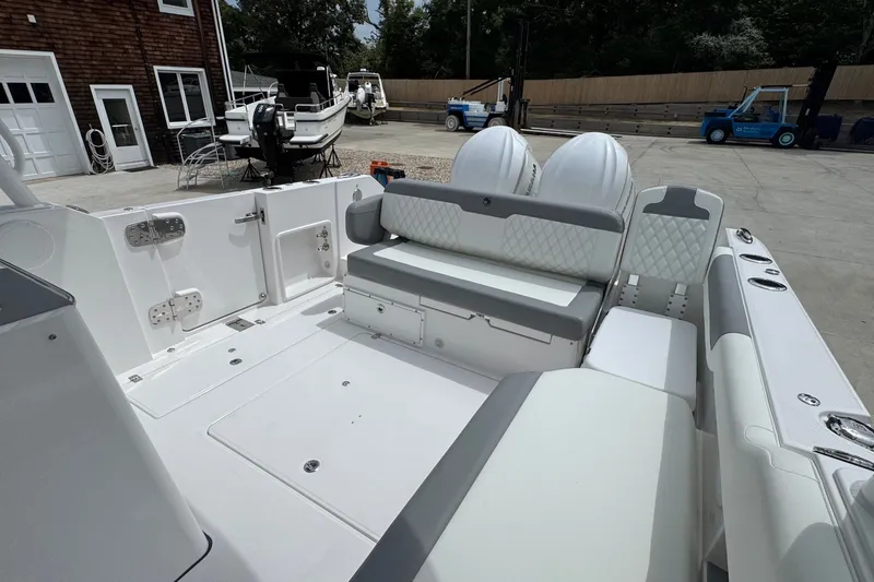Slide: The Image of Edgewater 310SC 2027 boat interior with seating and dual engines in a marina setting. - 16