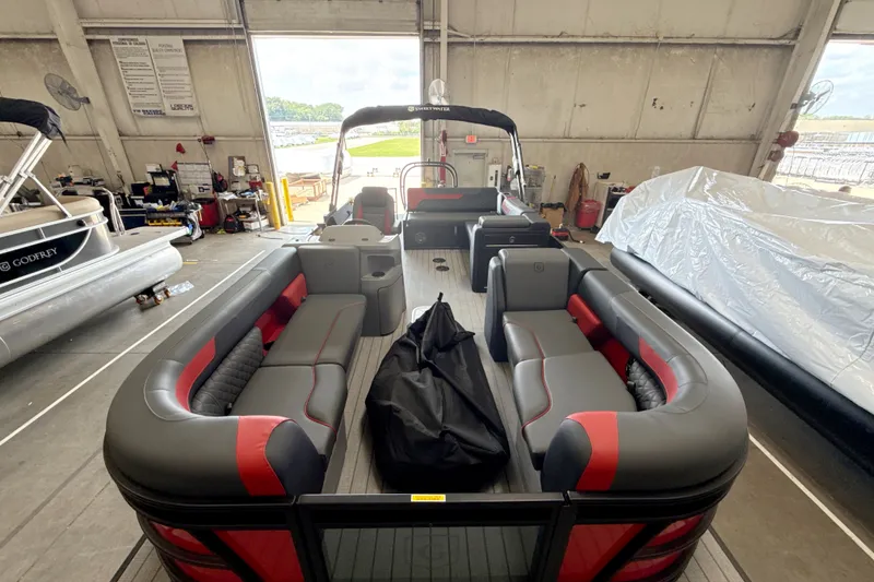 Slide: The Image of 2026 Godfrey Sweetwater 2286 SFL pontoon boat in a storage facility, showcasing spacious seating. - 17