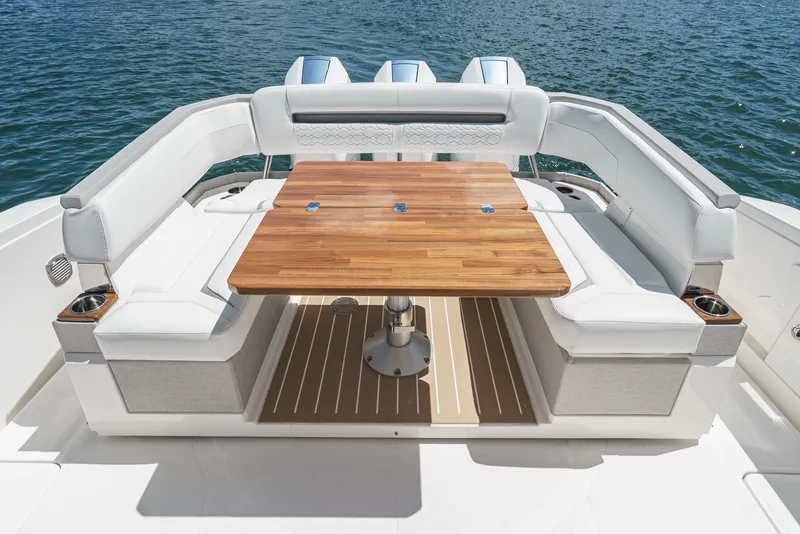 Slide: The Image of The 2024 Tiara Yachts 38 LS features a luxurious seating area with a wooden table overlooking the water. - 27
