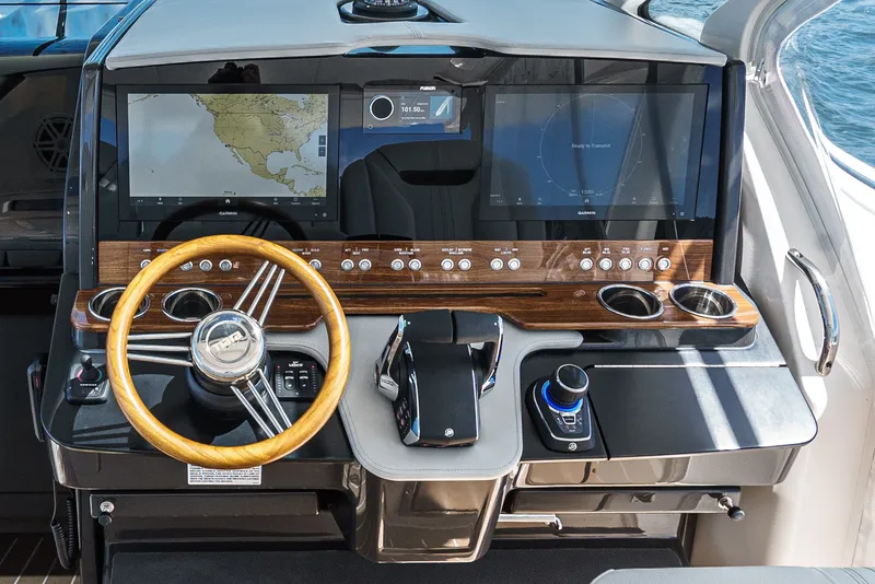 Slide: The Image of The 2024 Tiara Yachts 38 LS cockpit features a sleek design with a wooden steering wheel and modern displays. - 43