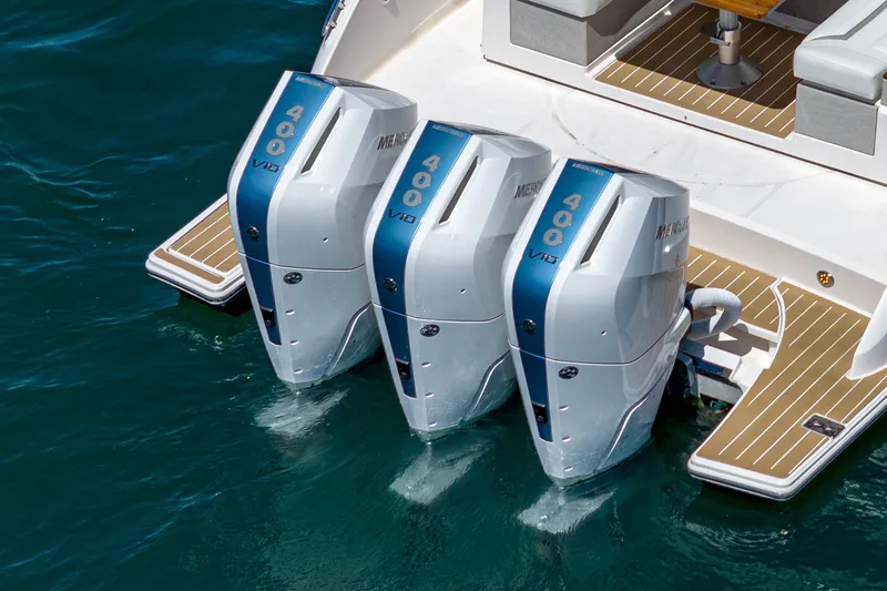 Slide: The Image of Three powerful outboard engines on a luxury boat resting on calm water. - 22
