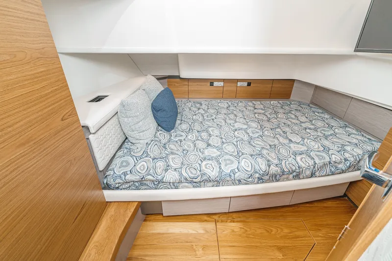 Slide: The Image of Cabin of the 2024 Tiara Yachts 38 LS with a cozy bed and wooden flooring. - 47