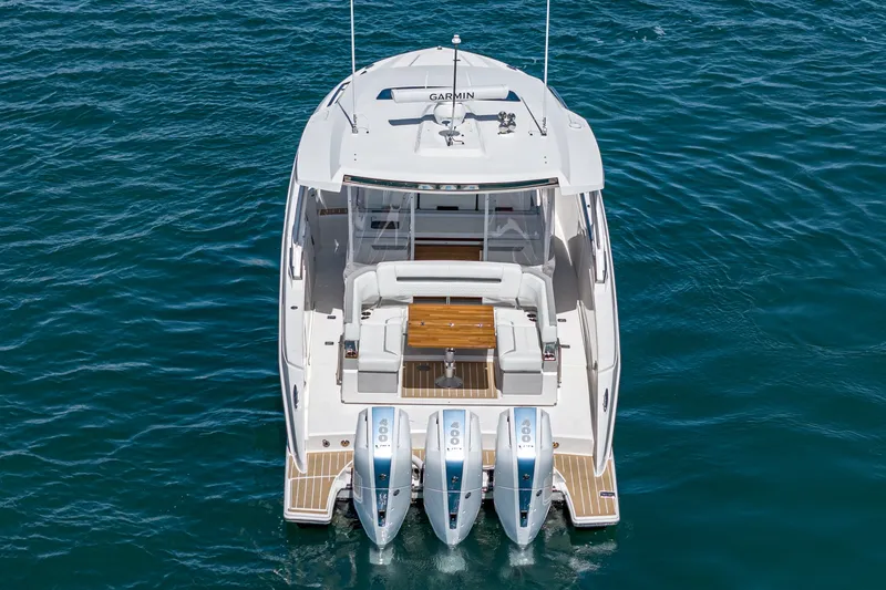 Slide: The Image of The 2024 Tiara Yachts 38 LS is a sleek boat with three outboard engines and a spacious deck. - 19