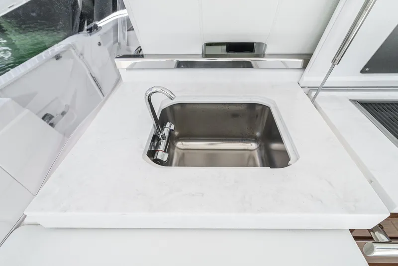 Slide: The Image of A sleek stainless steel sink is set into a white countertop on a Tiara Yachts 38 LS. - 37