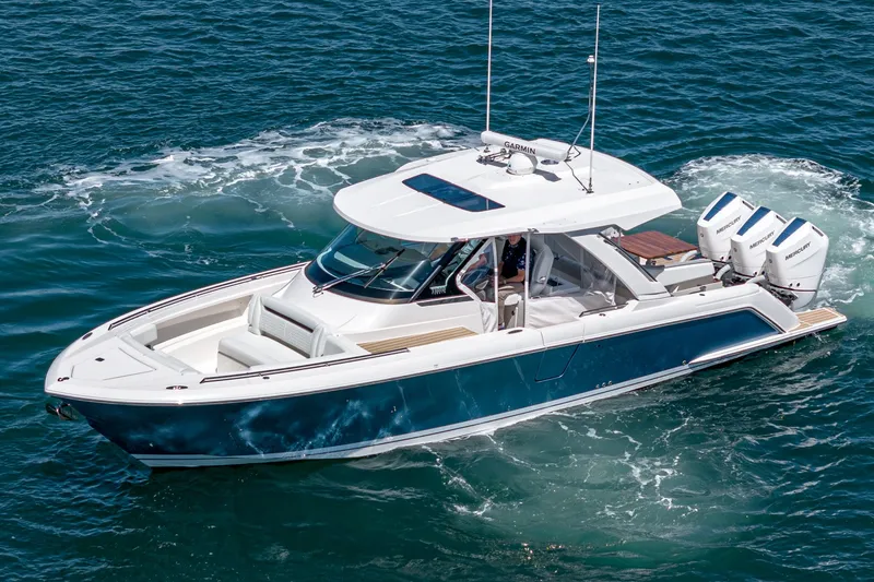 The Image of The 2024 Tiara Yachts 38 LS is a sleek motorboat with dual outboard engines on open water. - 0