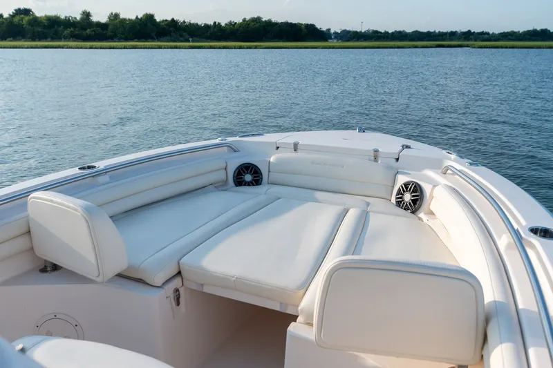 Slide: The Image of 2022 Grady-White Fisherman 216 boat interior with cushioned seating on calm water. - 18