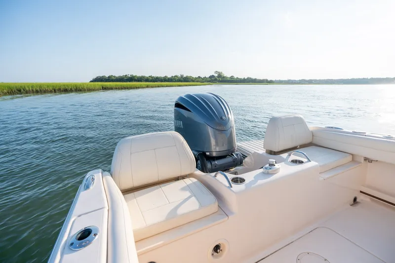 Slide: The Image of 2022 Grady-White Fisherman 216 boat on calm water, featuring comfortable seating and outboard motor. - 22
