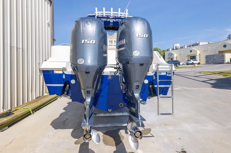 Slide: The Image of 2017 NauticStar 2602 Legacy boat with dual Yamaha 150 engines, docked outdoors. - 13