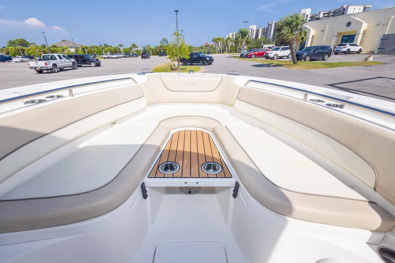 Slide: The Image of 2017 NauticStar 2602 Legacy boat interior with beige seating and wooden table. - 31