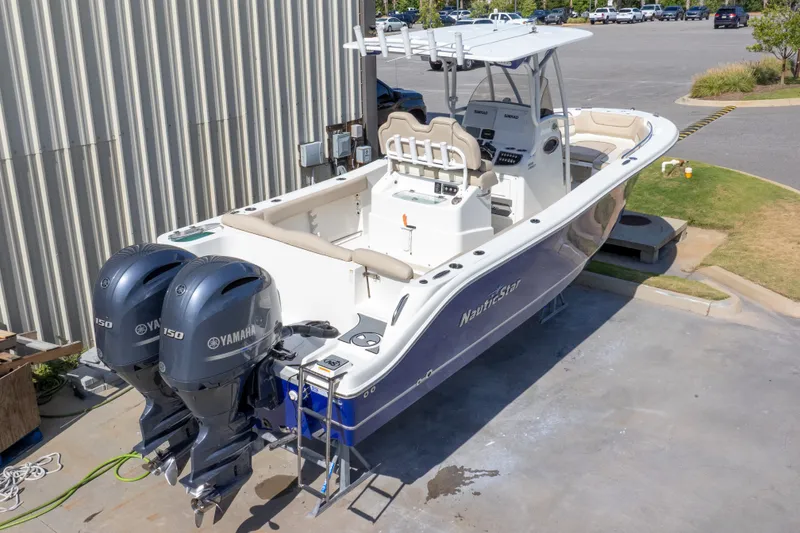 Slide: The Image of 2017 NauticStar 2602 Legacy boat with twin Yamaha engines, parked outdoors. - 49