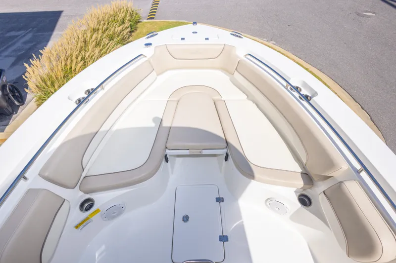 Slide: The Image of 2017 NauticStar 2602 Legacy boat interior with beige seating and storage compartments. - 26