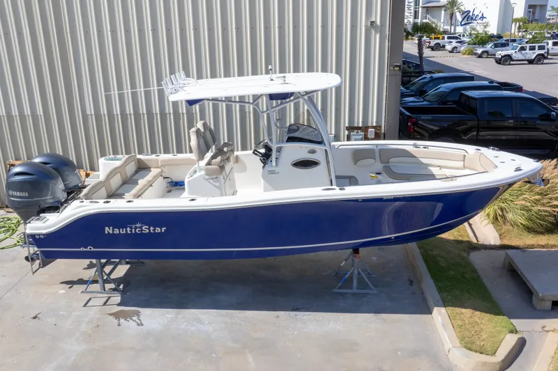 Slide: The Image of 2017 NauticStar 2602 Legacy boat with dual Yamaha engines, parked outdoors. - 1