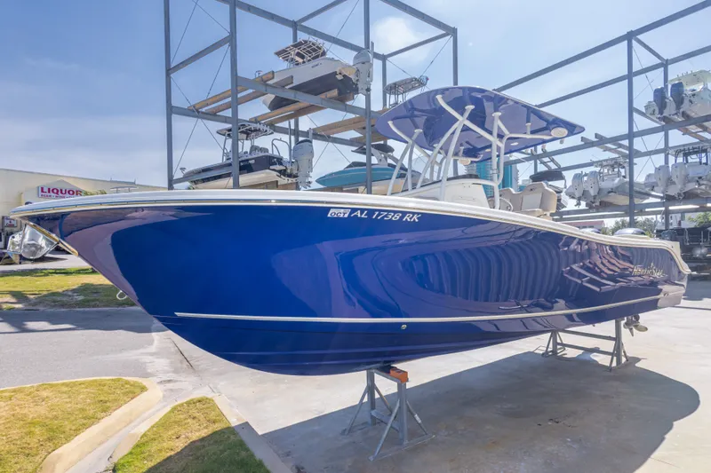Slide: The Image of 2017 NauticStar 2602 Legacy boat in vibrant blue, displayed on a stand outdoors. - 15