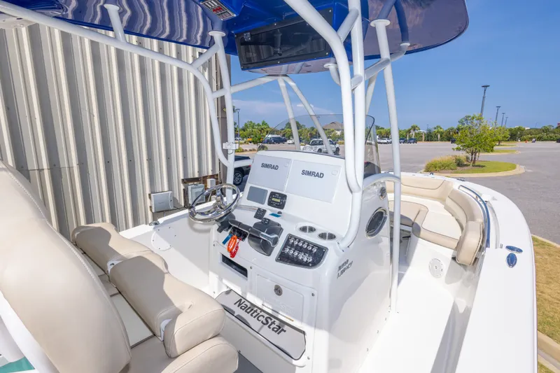 Slide: The Image of 2017 NauticStar 2602 Legacy boat interior with helm, seating, and Simrad electronics. - 19