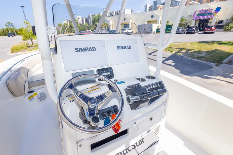 Slide: The Image of 2017 NauticStar 2602 Legacy boat helm with Simrad electronics and steering wheel. - 21