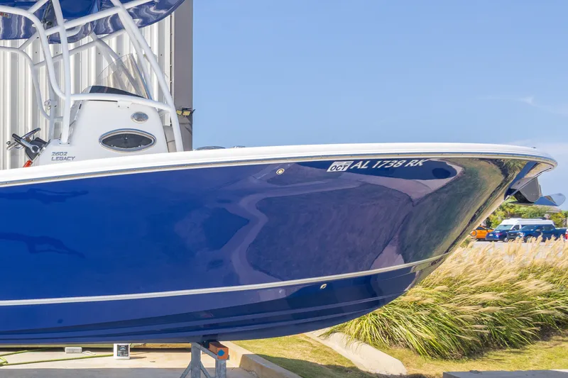 Slide: The Image of 2017 NauticStar 2602 Legacy boat with blue hull, docked outdoors. - 11