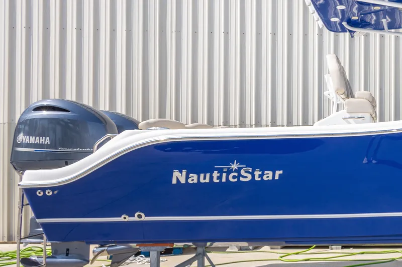 Slide: The Image of 2017 NauticStar 2602 Legacy boat with Yamaha engine, blue hull, docked outdoors. - 10