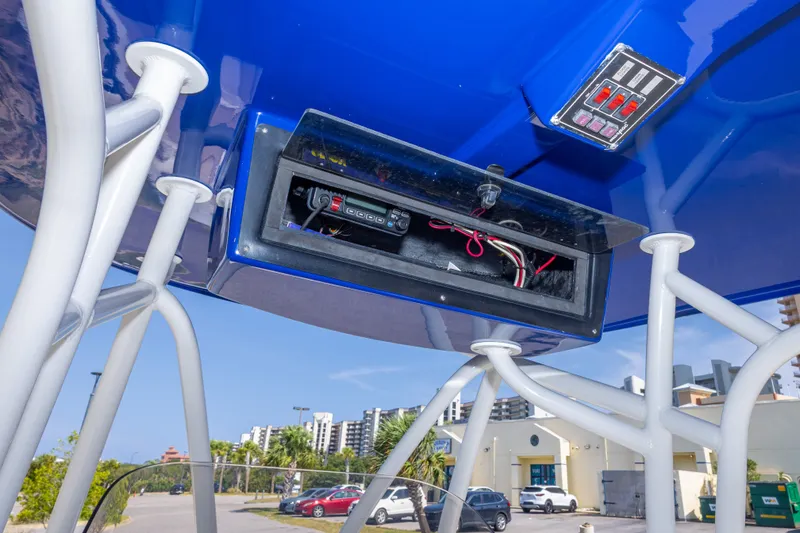 Slide: The Image of 2017 NauticStar 2602 Legacy boat electronics compartment with wiring, under blue canopy. - 22