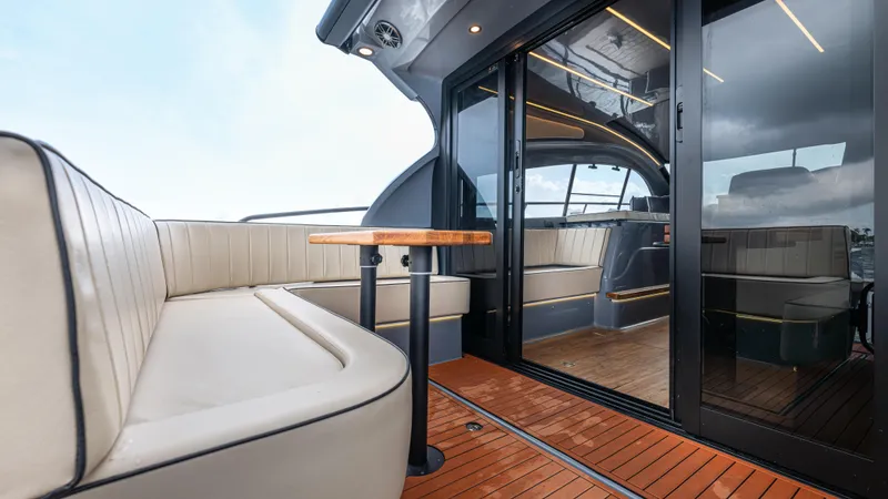 Slide: The Image of The image shows the deck of a modern yacht with sleek seating and a wooden table. - 38