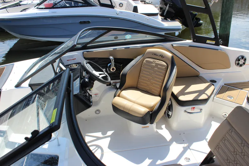Slide: The Image of 2025 Sea Ray SPX 210 Outboard boat interior with tan seating and modern dashboard. - 3