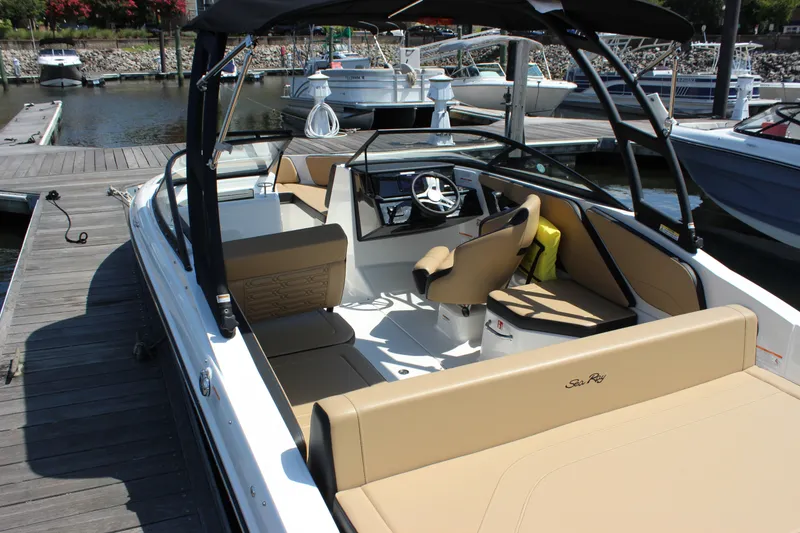 Slide: The Image of 2025 Sea Ray SPX 210 Outboard boat interior at dock, featuring tan seating and modern controls. - 7