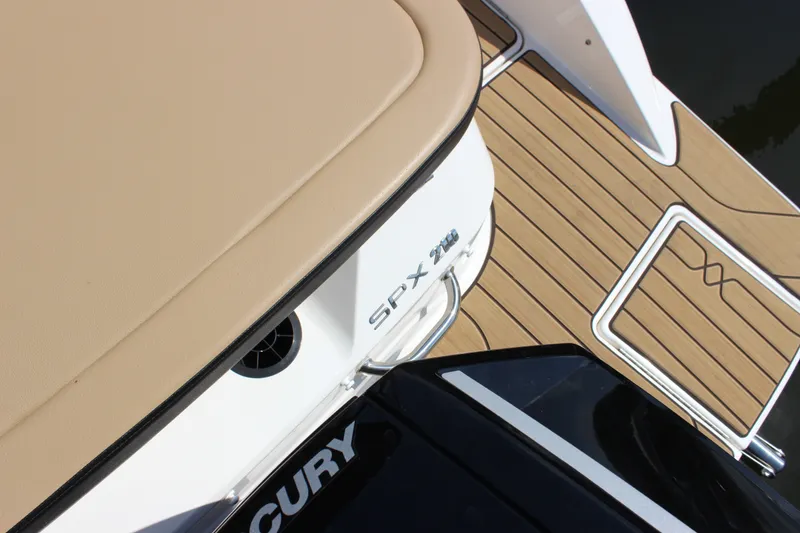 Slide: The Image of 2025 Sea Ray SPX 210 Outboard boat deck with tan seating and wood finish. - 8