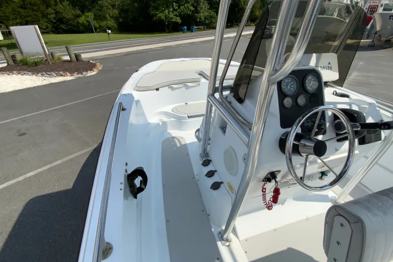 Slide: The Image of 2004 Triumph 190 Bay boat with steering console and gauges, parked outdoors. - 15