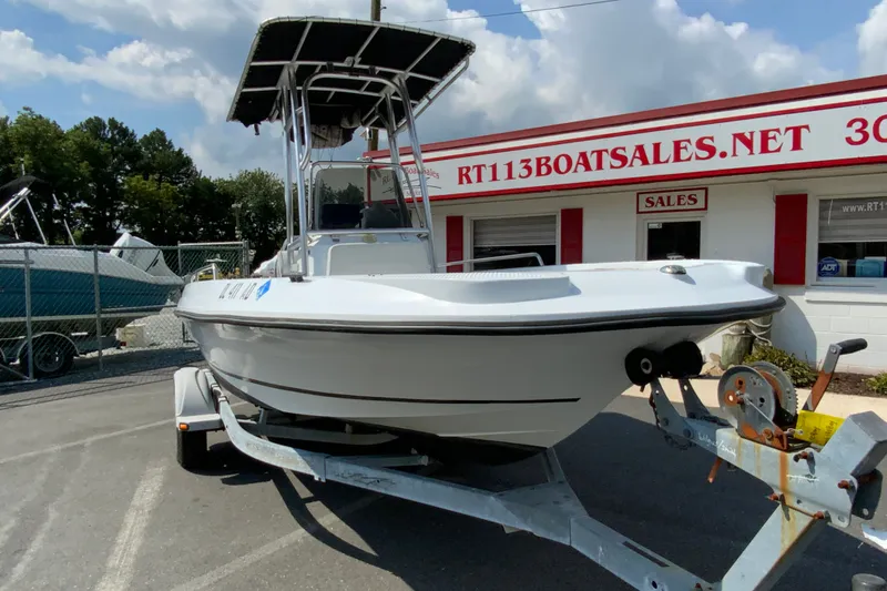 Slide: The Image of 2004 Triumph 190 Bay boat on trailer at dealership, under a cloudy sky. - 3