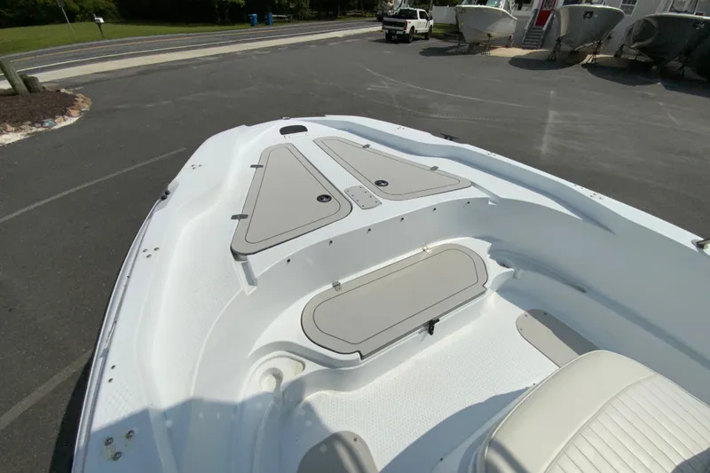 Slide: The Image of 2004 Triumph 190 Bay boat deck with storage compartments, parked outdoors. - 18