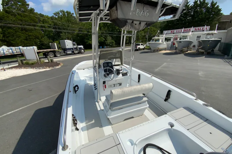 Slide: The Image of 2004 Triumph 190 Bay boat with center console, parked at a boat sales lot. - 9