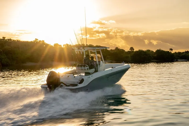 Slide: The Image of 2026 Bayliner Trophy T24CC boat cruising at sunset on a serene waterway. - 9