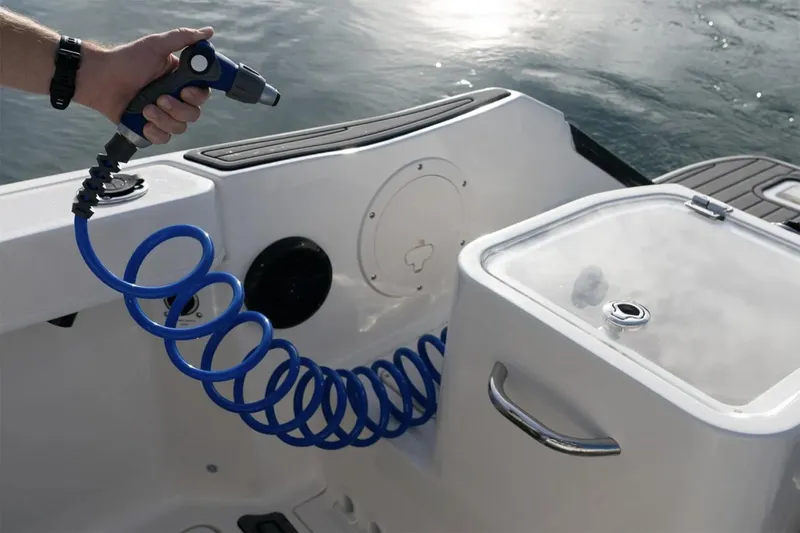 Slide: The Image of Manufacturer Provided Image: 2025 Bayliner Trophy T24CC boat deck with coiled hose and storage compartment. - 4