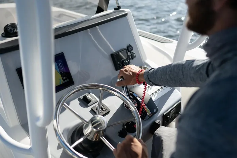 Slide: The Image of Manufacturer Provided Image: 2025 Bayliner Trophy T24CC boat dashboard with steering wheel and controls. - 5