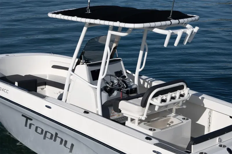 Slide: The Image of Manufacturer Provided Image: 2025 Bayliner Trophy T24CC boat with T-top and fishing rod holders on calm water. - 3