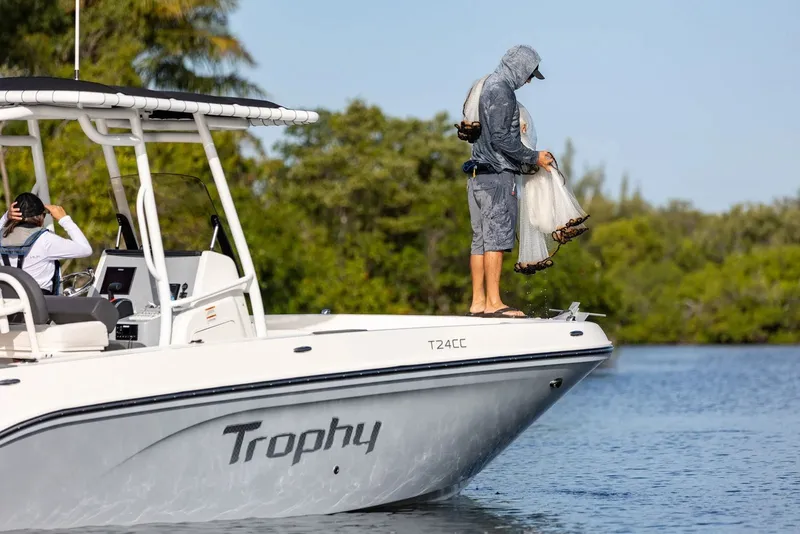 Slide: The Image of 2026 Bayliner Trophy T24CC boat with anglers fishing in a scenic waterway. - 10