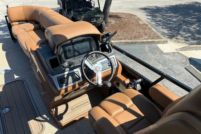 Slide: The Image of 2024 Regency 230 LE3 boat interior with tan leather seating and modern dashboard. - 6