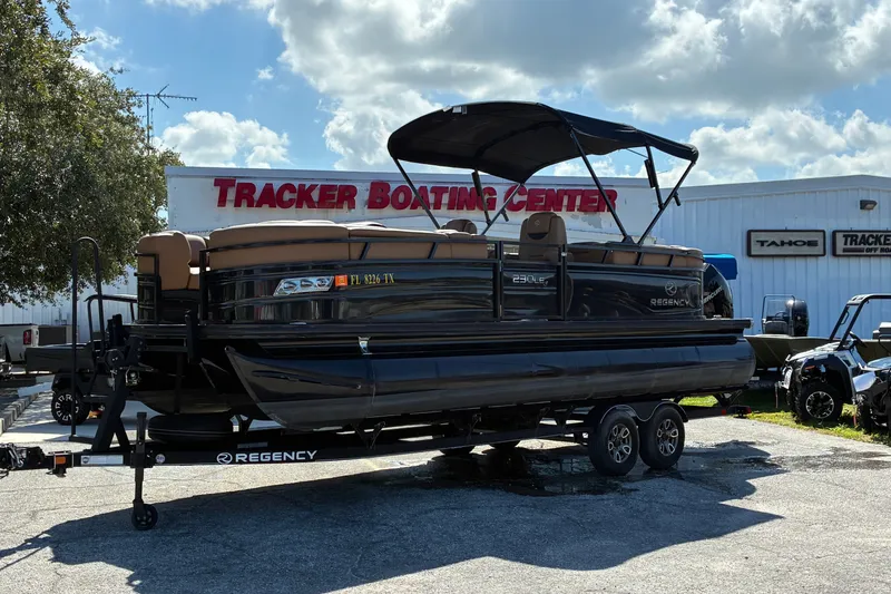 The Image of 2024 Regency 230 LE3 pontoon boat at Tracker Boating Center under a cloudy sky. - 0