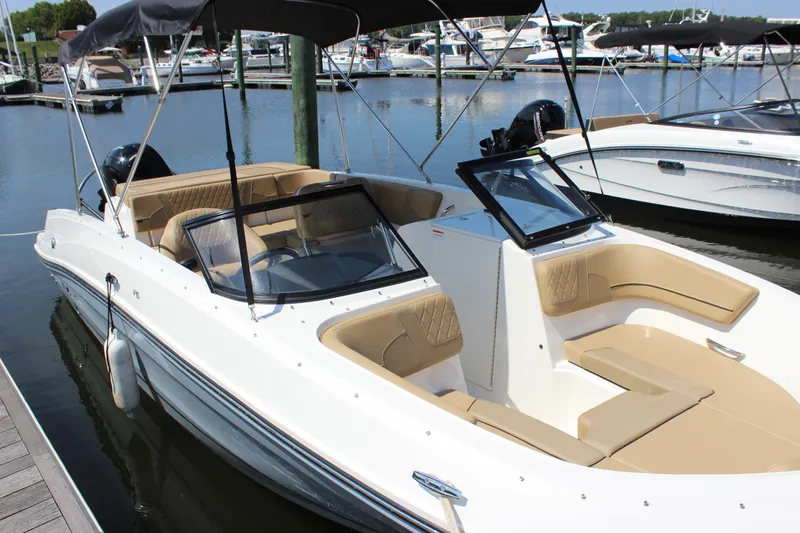 Slide: The Image of 2026 Bayliner VR6 Bowrider OB docked at marina, featuring spacious seating and sleek design. - 2