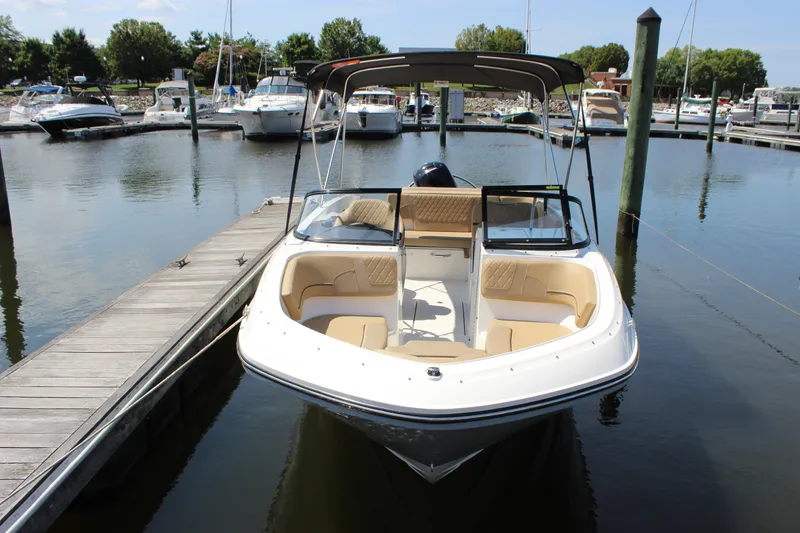 The Image of 2026 Bayliner VR6 Bowrider OB docked at marina, featuring spacious seating and sleek design. - 1