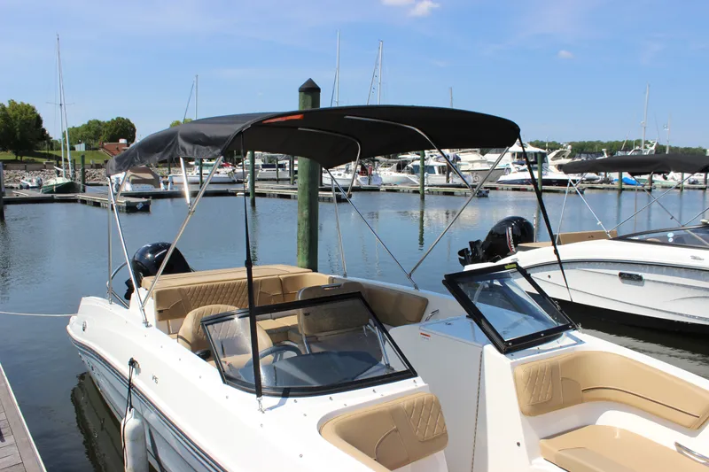 Slide: The Image of 2026 Bayliner VR6 Bowrider OB docked at a marina with canopy. - 3