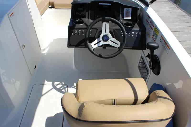 Slide: The Image of 2026 Bayliner VR6 Bowrider OB cockpit with steering wheel and beige seating. - 8