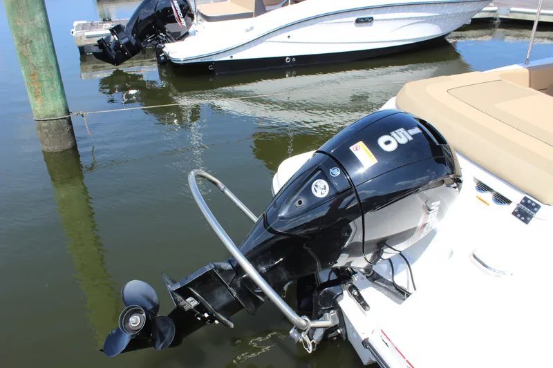 Slide: The Image of 2026 Bayliner VR6 Bowrider OB with outboard motor docked on calm water. - 4