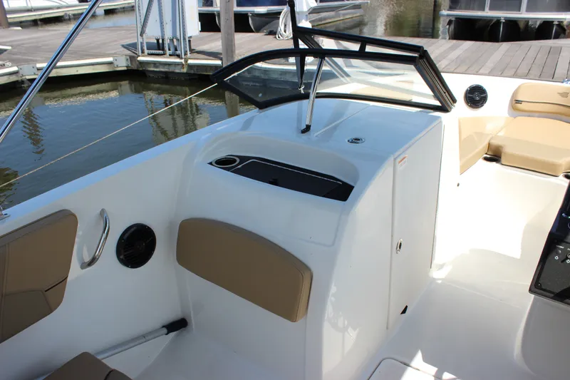 Slide: The Image of 2026 Bayliner VR6 Bowrider OB interior with seating and console at marina. - 10
