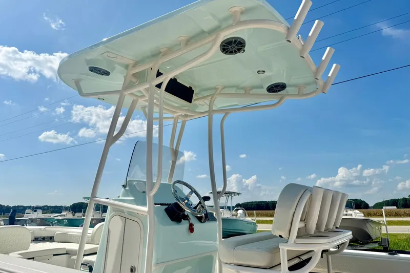 Slide: The Image of 2027 Carolina Skiff 26 Ultra Elite boat with T-top and seating, under clear blue sky. - 45
